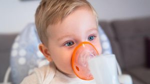 Bambino neonato con inalatore per asma