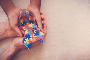 Mani tengono puzzle autismo a forma di fiocco