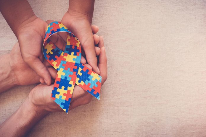 Microbioma intestinale e autismo: ulteriore conferma arriva da studio USA Mani tengono puzzle autismo a forma di fiocco
